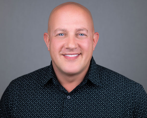 A man with bald head and blue eyes.