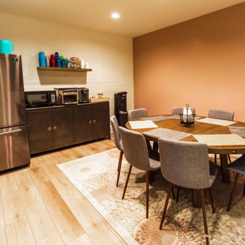 A dining room with a round table and chairs.