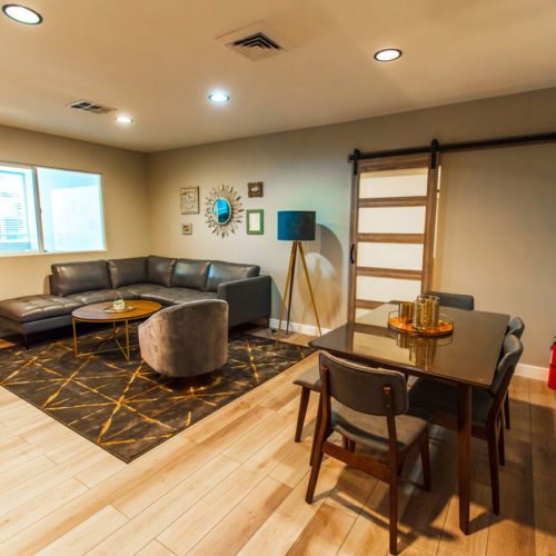 A living room with a couch, table and chairs.
