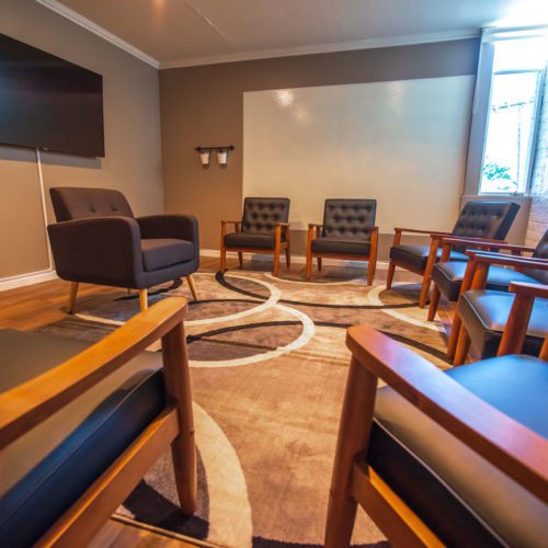 A room with several chairs and a television.