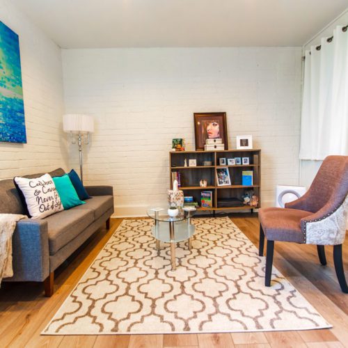 A living room with a couch, chair and coffee table.