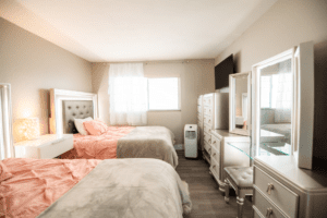 A bedroom with two beds and a dresser