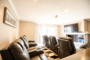 A room with several couches and recliners in it
