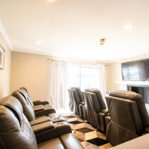 A room with several couches and recliners in it