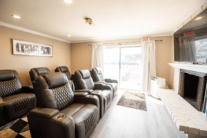 A room with several leather chairs and a window.