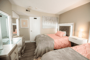 A bedroom with two beds and a dresser.