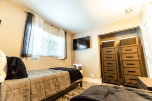 A bedroom with two beds and a television.