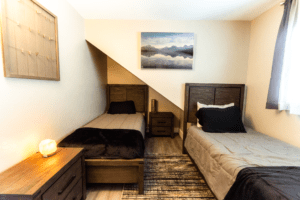 A bedroom with two beds and a dresser.