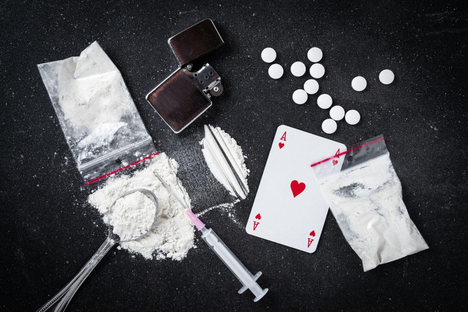 A table with drugs, pills and playing cards.