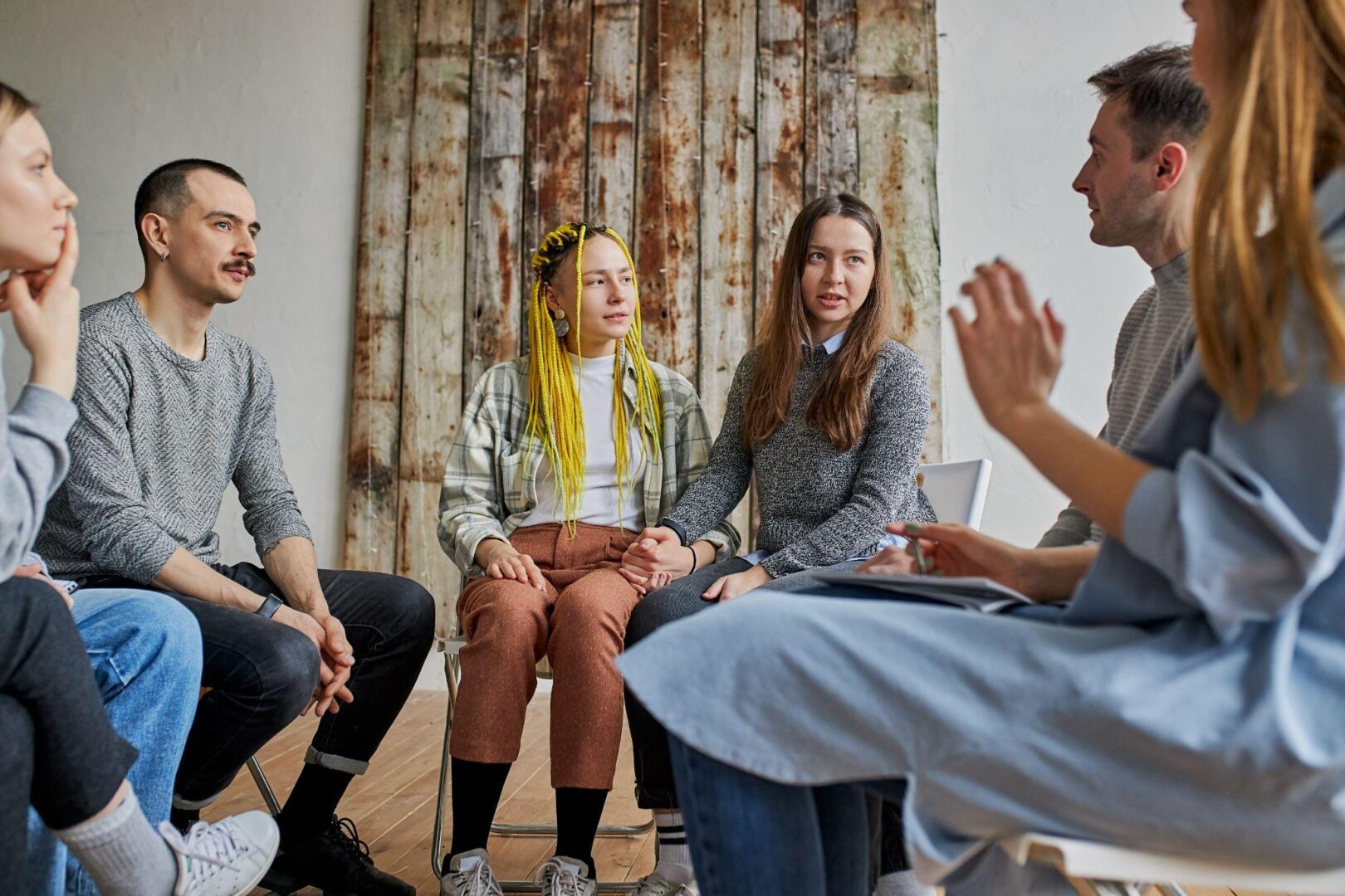 A group of people sitting in a circle talking.