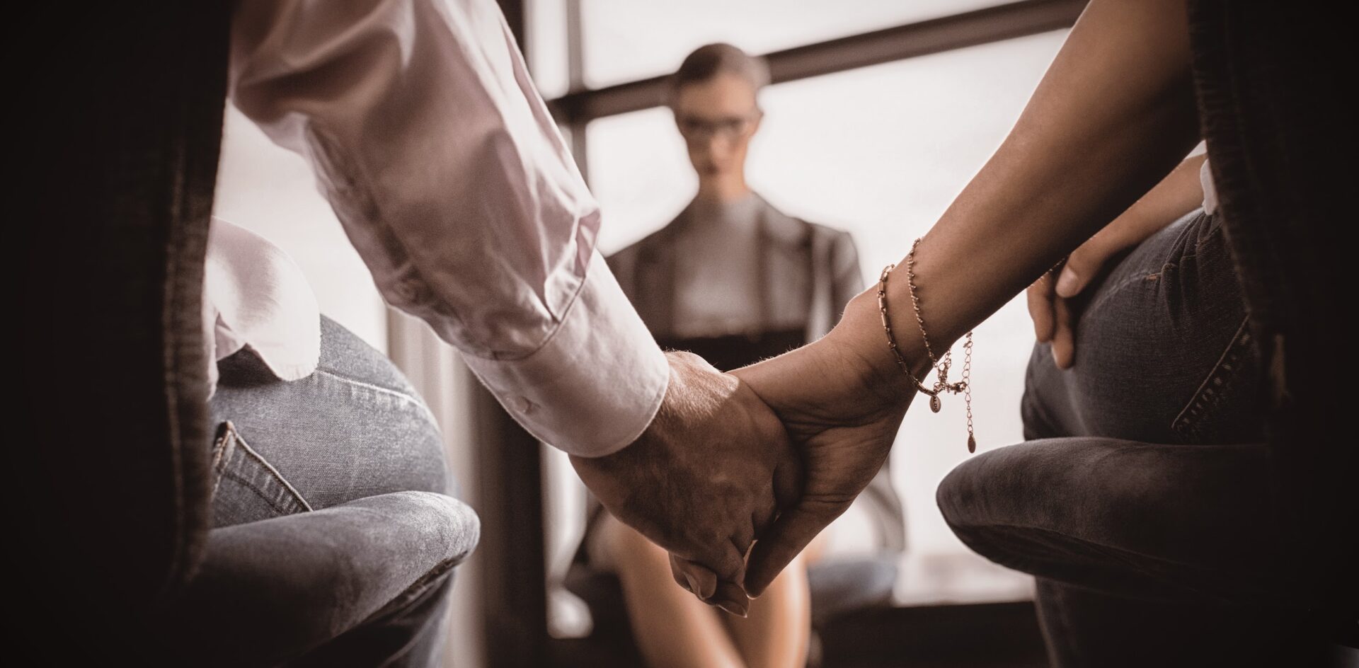 A man and woman holding hands in front of a window.