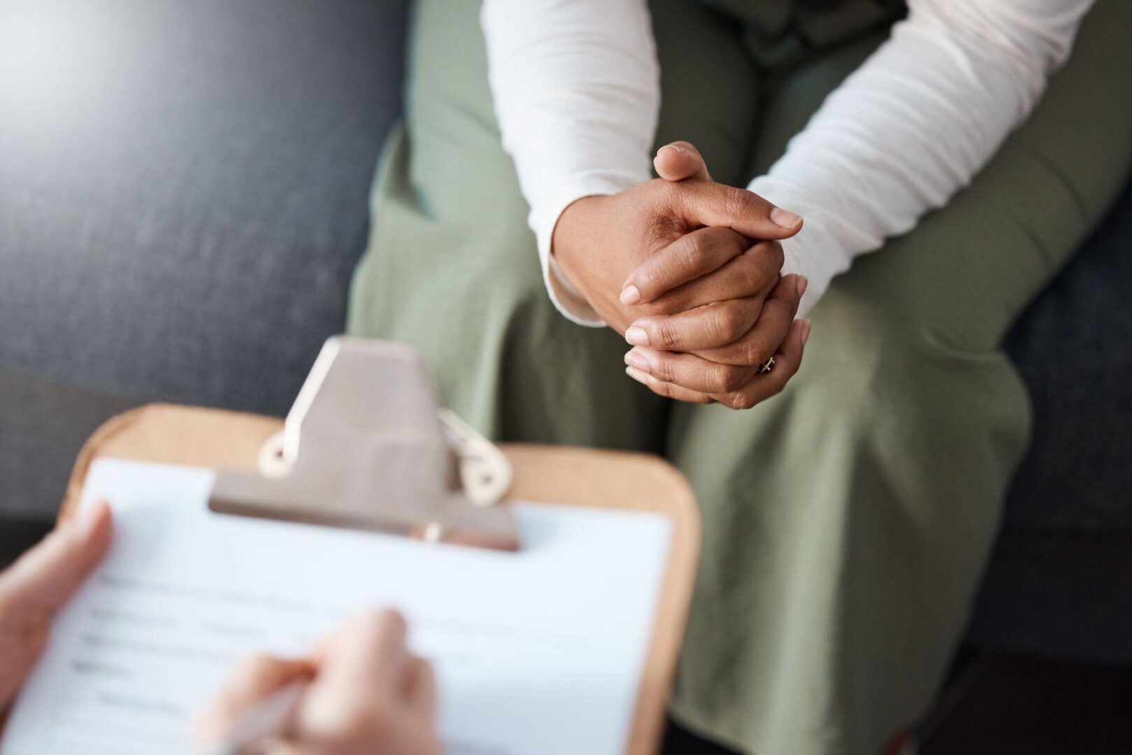 A person sitting in front of another person holding their hands.